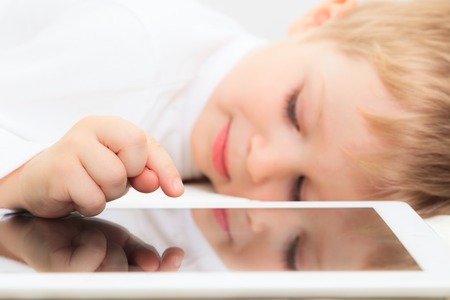 Little boy with touch pad, modern technology and learningの写真素材