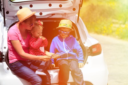 mother with kids looking at map while travel by carの写真素材