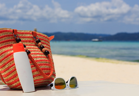 bag, sun glasses and suncream on tropical beach, vacation conceptの写真素材