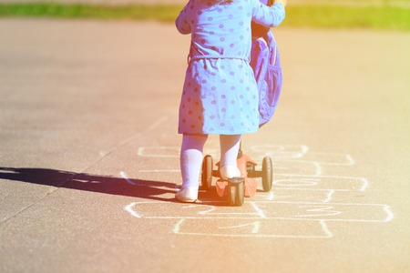 little girl playing hopscotch on playground outdoorsの写真素材