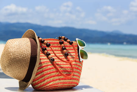 hat, bag and sun glasses on tropical beach, vacation conceptの写真素材