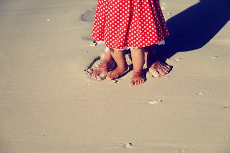 Close up of father and little daughter feet on a tropical beachの写真素材