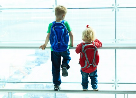 little boy and toddler girl looking at planes in the airport, kids travelの写真素材