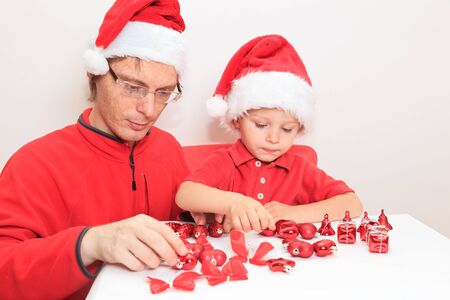 father and little boy in Santa hat sorting Christmas gifts, Christmas conceptの写真素材