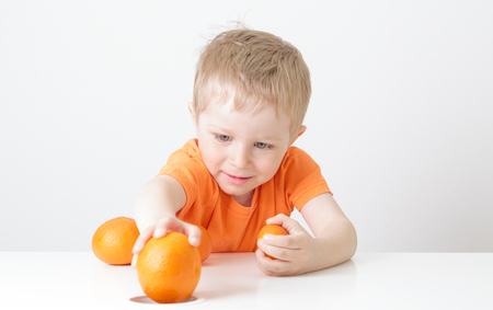 little boy with oranges, healthy food conceptの写真素材