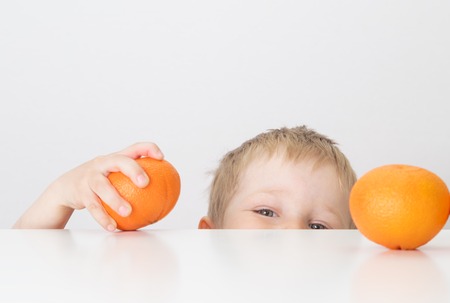little boy with oranges, healthy food conceptの写真素材