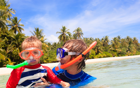 happy father and son snorkeling on tropical beachの写真素材