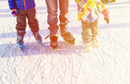 father with two kids skating in winter, family winter sportの写真素材
