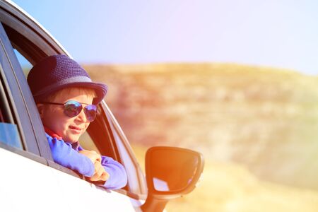happy little boy travel by car in mountains, kids travel