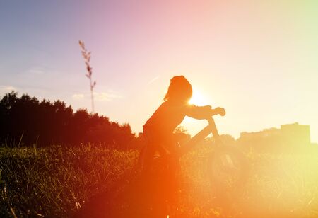 little girl riding bike at sunset, active kids sportの写真素材