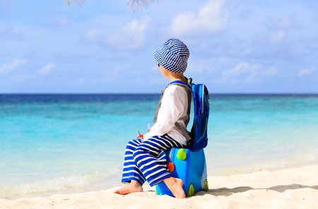 little boy travel on summer tropical beach with suitcase, kids travelの写真素材