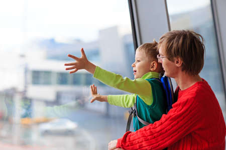 family travel- father and son looking at planes in the airportの写真素材