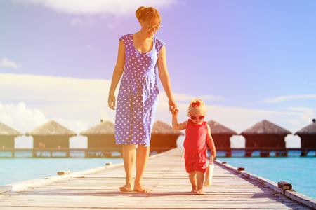 mother and little daughter walking on beach tropical reportの写真素材