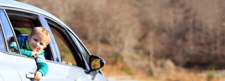 happy little boy travel by car in nature, wide panoramaの写真素材
