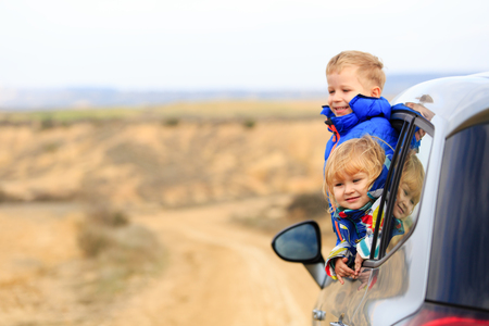 little girl and boy travel by car in mountains, kids travelの写真素材