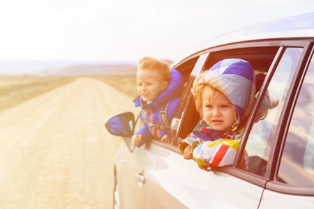 little girl and boy travel by car on the road, kids travelの写真素材