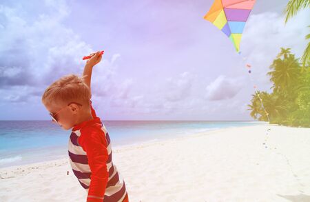 Little boy flying a kite on tropical beach, kids beach activitiesの写真素材