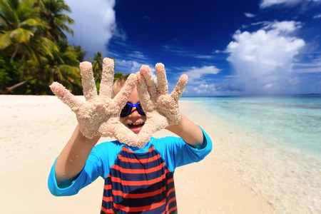 little boy having fun on tropical beach vacationの写真素材