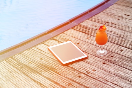 cocktail and touch pad at the pool on beach, communication conceptの写真素材