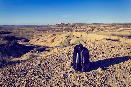 backpack and thermos in mountains, travel concept