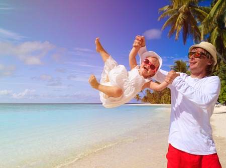 father and little daughter play at beach, family vacationの写真素材