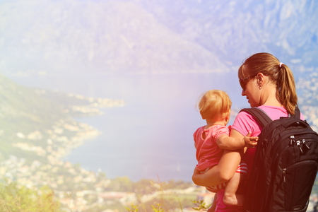 mother with little daughter looking at mountains on vacationの写真素材