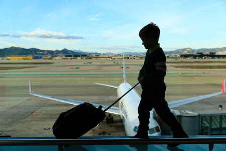 little boy with suitcase waiting in the airport, kids travelの写真素材