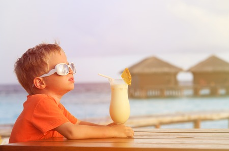 little boy drinking cocktail on tropical beach vacationの写真素材