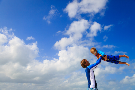 Father and little son playing on summer skyの写真素材