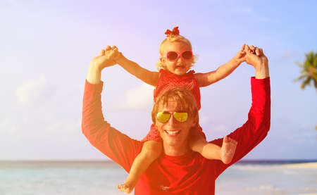 Happy father and cute little daughter at beachの写真素材