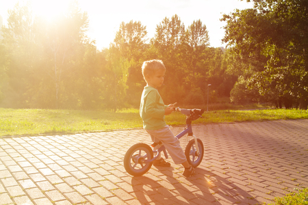little boy riding bike at sunset, active kidsの写真素材