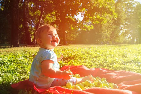 little girl picking apples in the garden, kids garden activitiesの写真素材