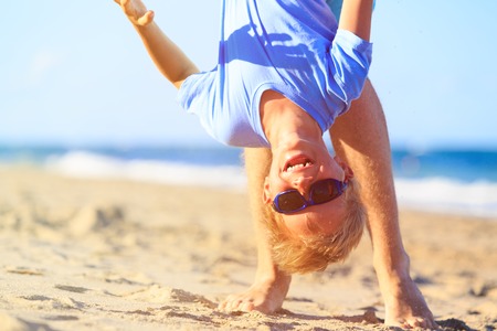 father and little son playing on summer beach