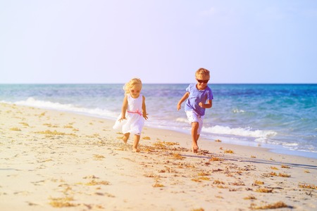 little boy and girl running at summer beachの写真素材