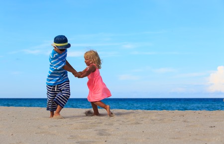 little boy and girl play on summer beachの写真素材
