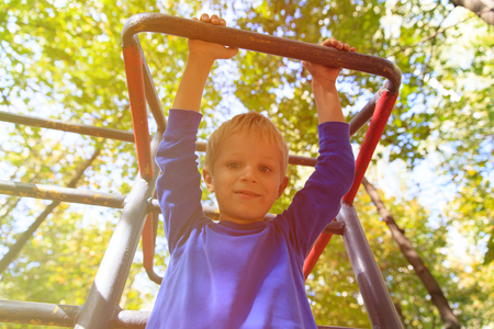 little boy playing on monkey bars in nature, kids sport
