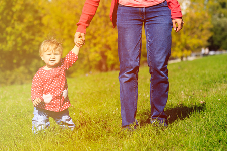 mother with little daughter walking in autumn nature, family autumn activitiesの写真素材
