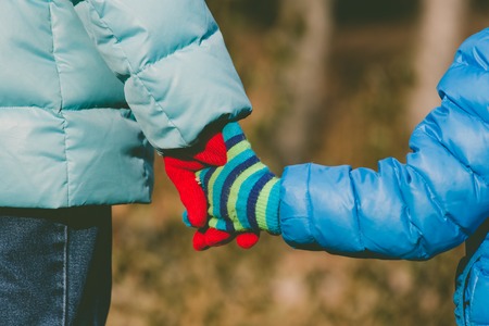Mother holding hand of her little son in autumnの写真素材