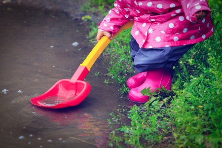child playing in water puddle, kids outdoor activitiesの写真素材