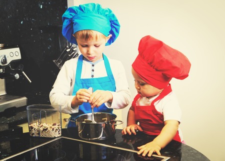 little boy and girl enjoy cooking in kitchen interiorの写真素材