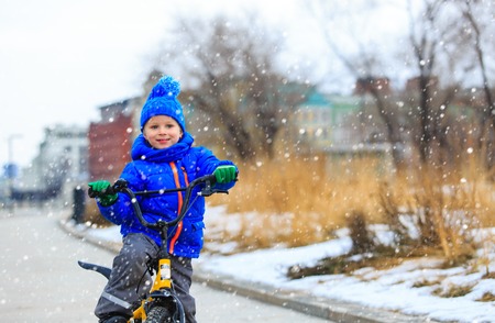 happy cute little boy riding bike in winter, kids sportの写真素材