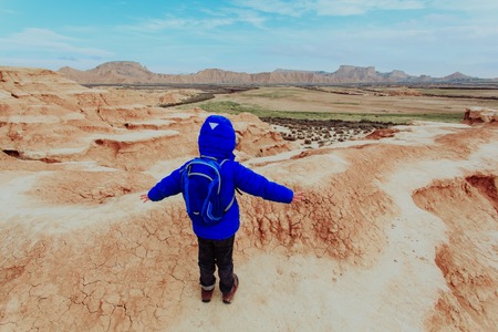 little boy with backpack hiking in scenic mountainsの写真素材