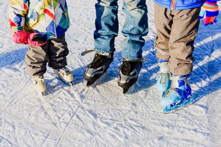 father with two kids skating in winter snow, family winter sportの写真素材