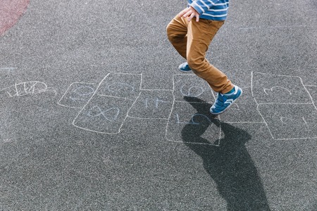 kid playing hopscotch on playground, children outdoor activitiesの写真素材