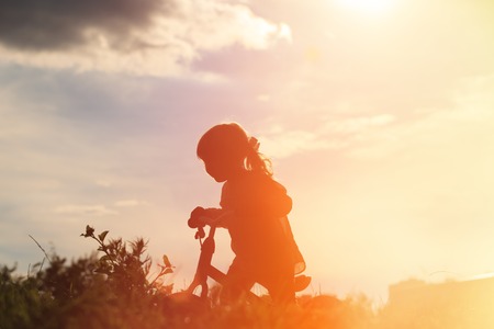 little girl riding bike at sunset sky, active kidsの写真素材