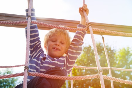 little boy playing on monkey bars at playground, kids sport and play