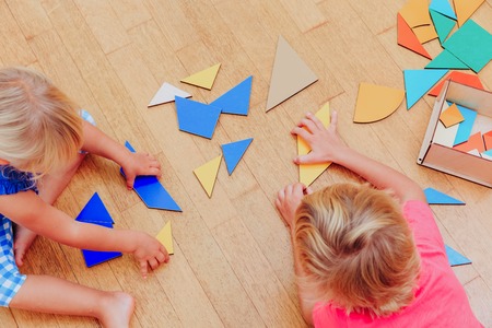 kids learning -little boy and girl playing with geometric shapes or puzzleの写真素材