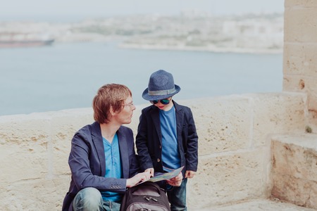family travel in Europe- father and little son looking at map in Malta