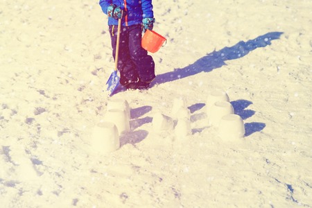 kids play in winter snow- little boy building snowcastleの写真素材