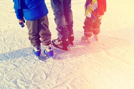 father with two kids skating in winter, family winter sportの写真素材